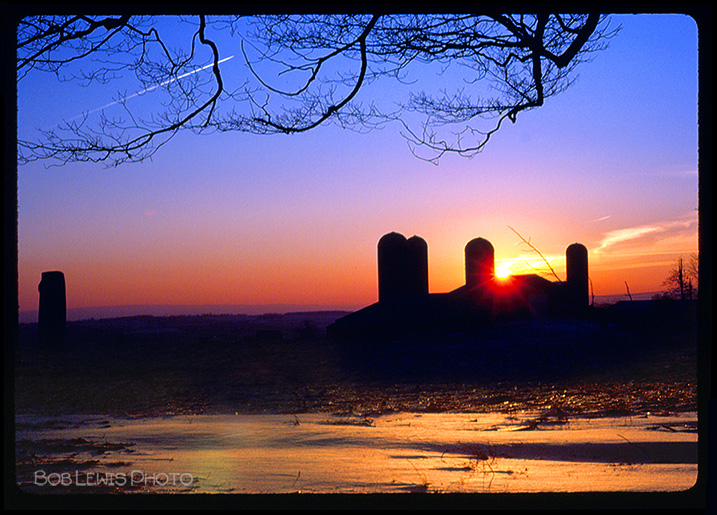 NY state farm with silo at sunset